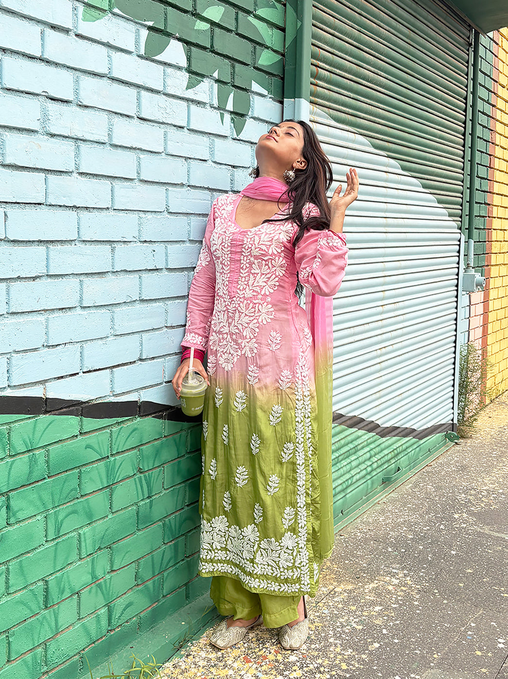 Female model wearing a muslin straight kurta set with detailed Chikankari embroidery, matching bottoms and a coordinated dupatta in an outdoor fashion photoshoot.