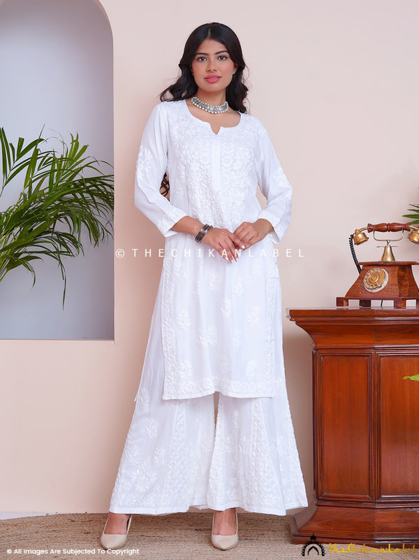 Woman wearing white chikankari kurti set with matching palazzo
