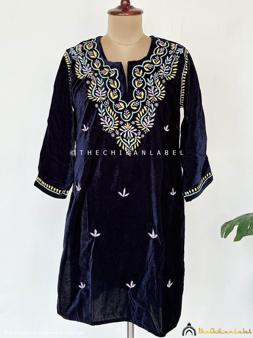 Premium velvet chikankari short kurta featuring detailed pastel thread embroidery displayed on a model for festive and winter styling.