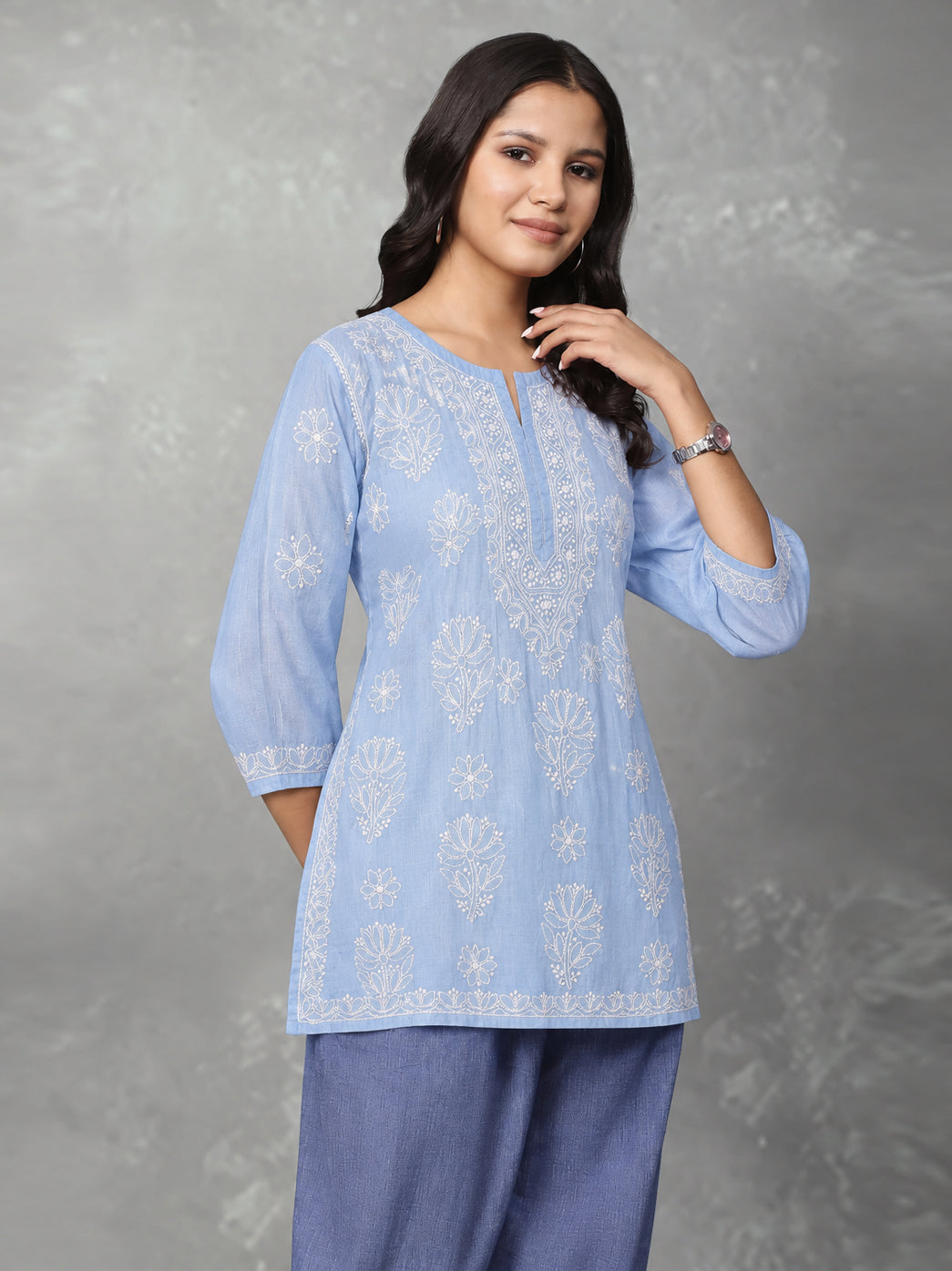 Ziva cotton Chikankari kurti showing a symmetrical arrangement of embroidery around the neckline and scattered floral designs extending down the front.