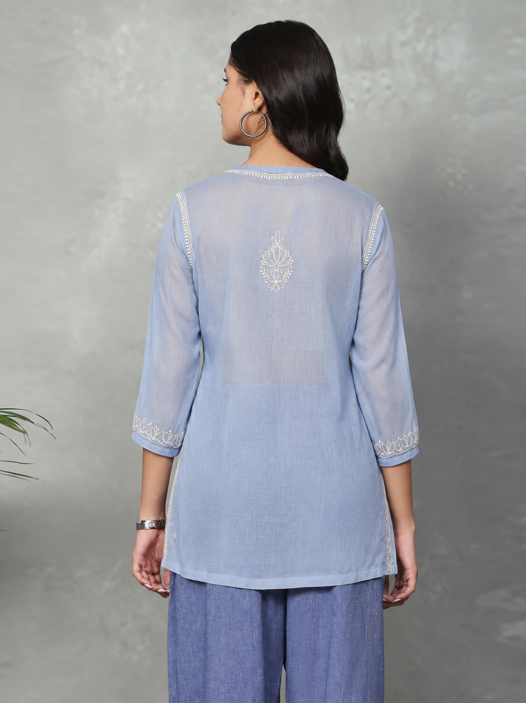 Hanging display of the Ziva Cotton Short Kurti, with the front embroidery, shoulder detailing, notched neckline and embroidered hem clearly visible.