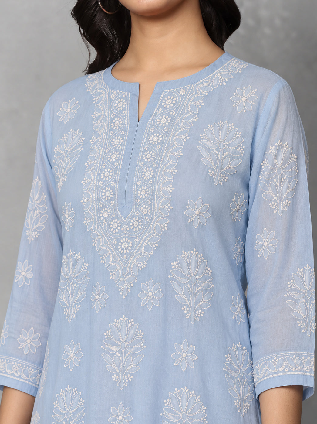 Ziva Cotton Short Kurti with three-quarter sleeves, showing floral embroidery on the upper sleeves and delicate decorative stitching near the cuffs.