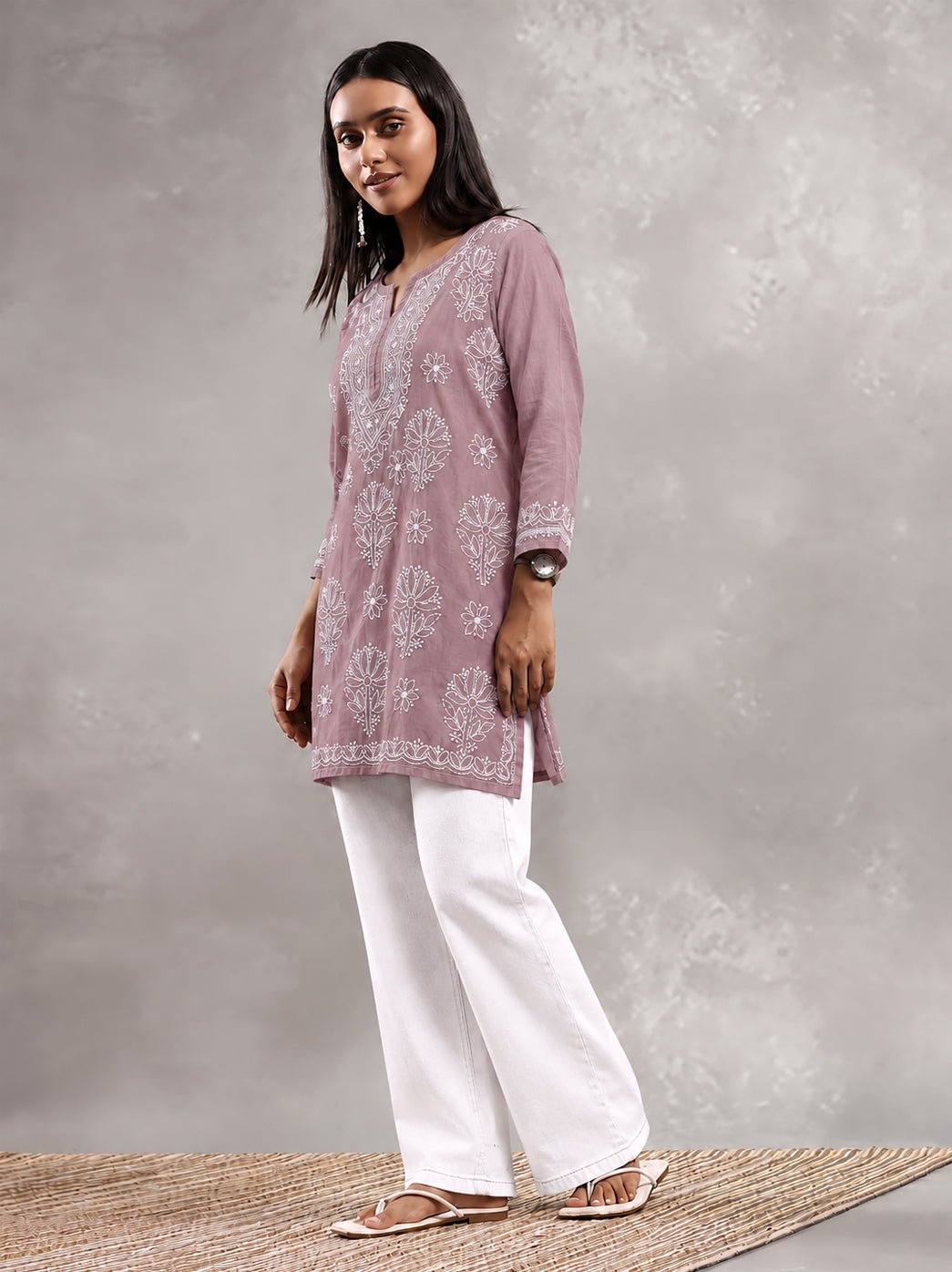 Everyday cotton Chikankari kurti displayed on a hanger, highlighting its short silhouette, three-quarter sleeves and floral embroidery across the front.