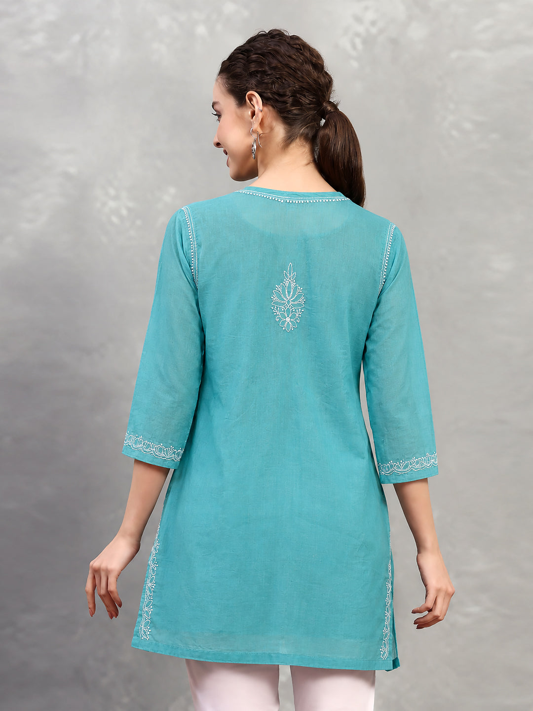 Ziva Cotton Short Kurti with three-quarter sleeves, showing floral embroidery on the upper sleeves and delicate decorative stitching near the cuffs.