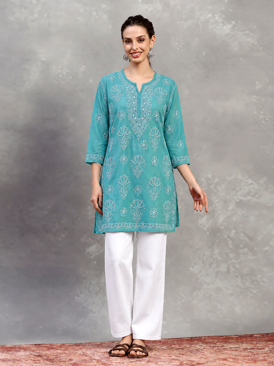 Hanging display of the Ziva Cotton Short Kurti, with the front embroidery, shoulder detailing, notched neckline and embroidered hem clearly visible.