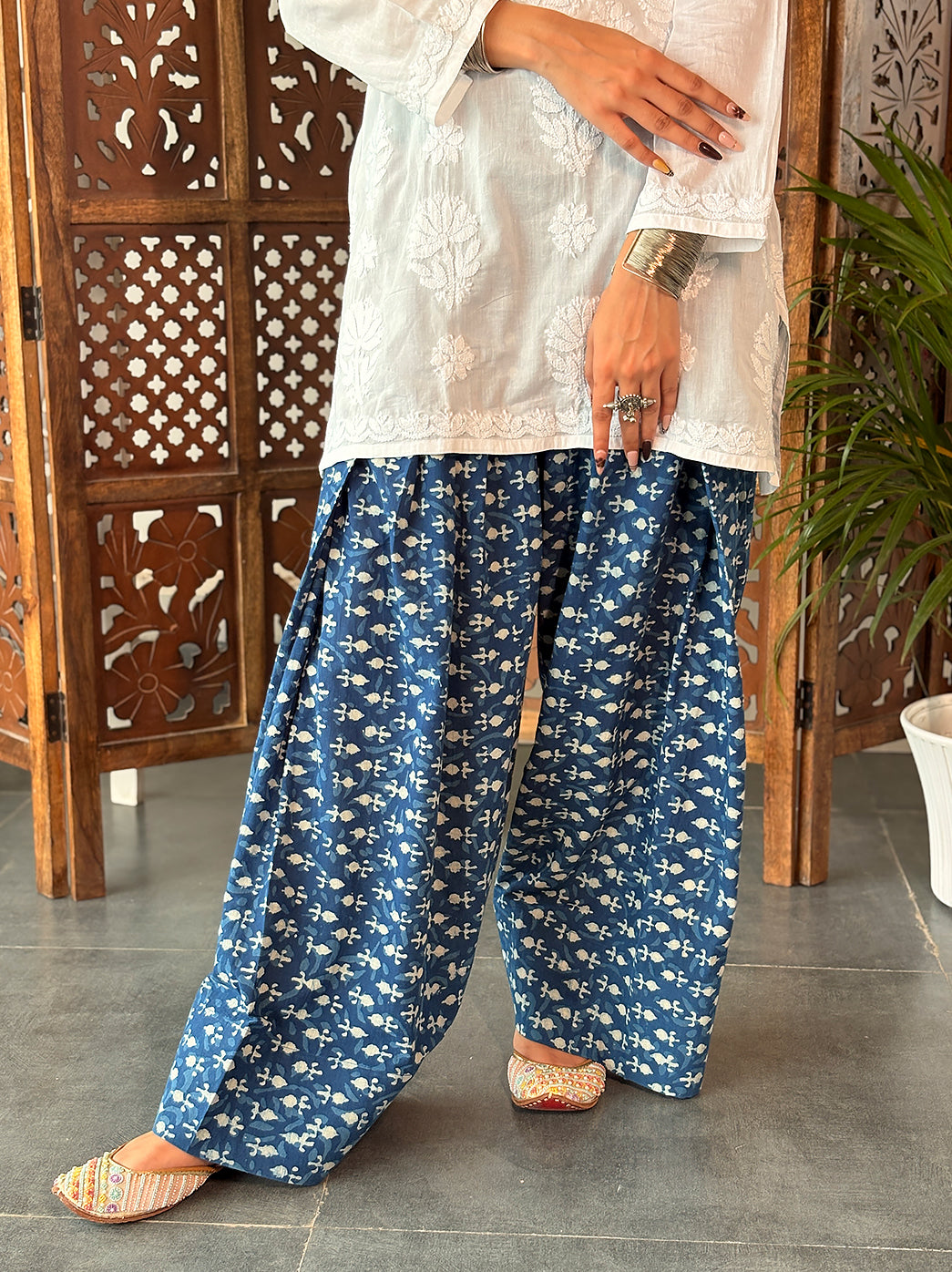 Everyday cotton Chikankari kurti displayed on a hanger, highlighting its short silhouette, three-quarter sleeves and floral embroidery across the front.